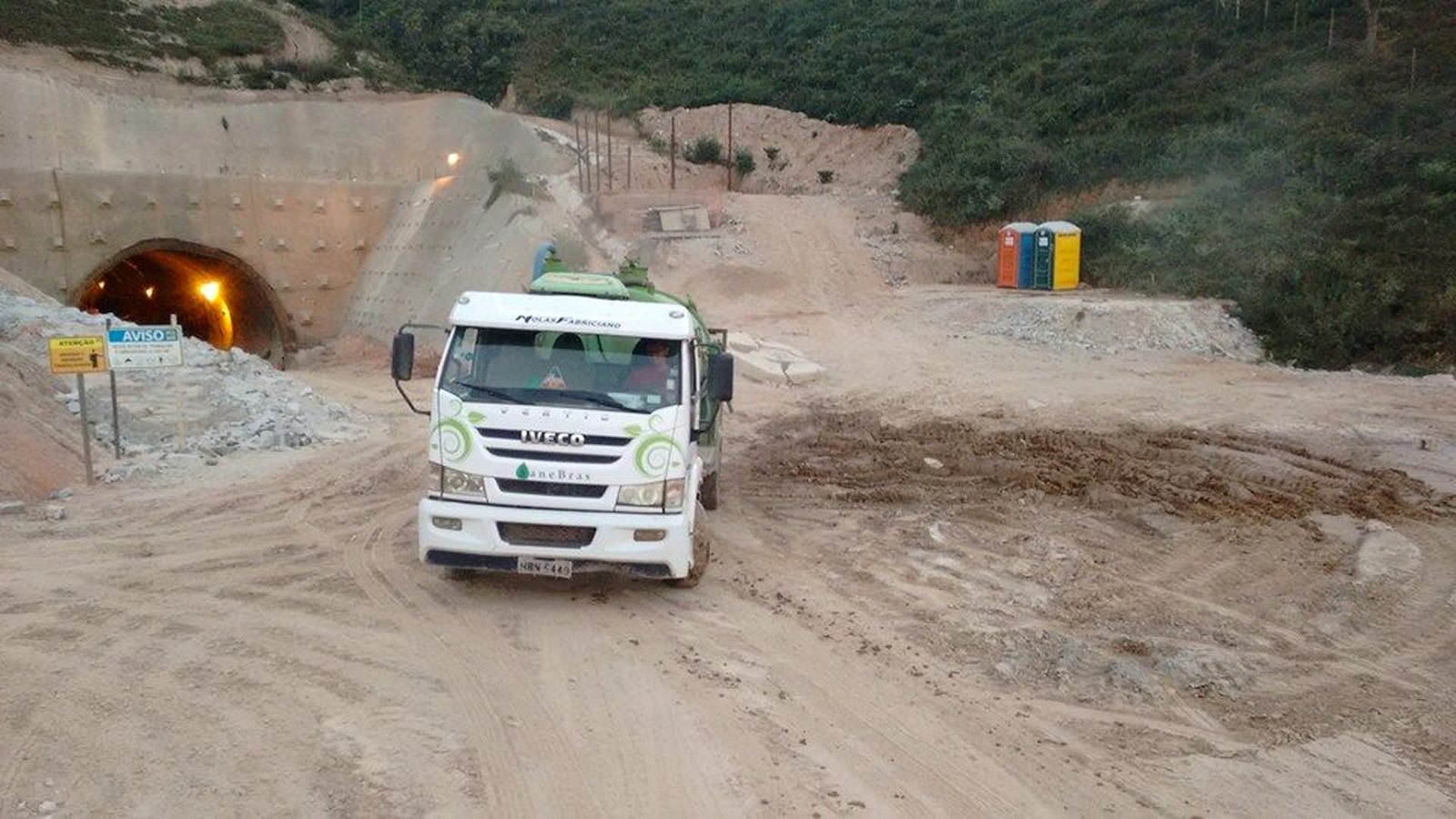 Caminhão da Sanebras em canteiro de obra rodoviária com banheiros químicos instalados na frente de trabalho